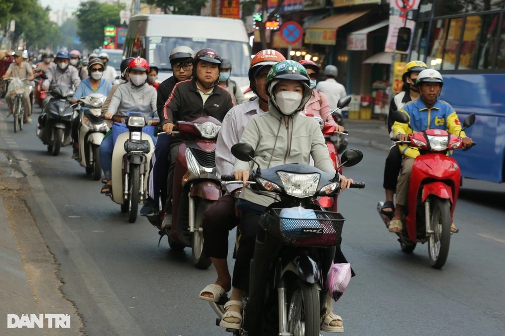 Người dân tại TPHCM mặc thêm áo giữ ấm khi ra đường vào sáng sớm (Ảnh: An Huy)